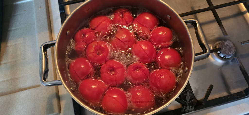 Sparzone pomidory w wodzie z widoczną, odchodzącą skórką
